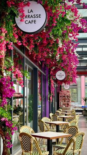 a row of tables and chairs with flowers on a restaurant at Flamingos Hải Tiến in Nam Khê