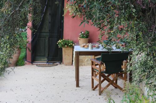 a table and a chair in front of a building at Orgon Farm Traditional Houses in Apóstoloi