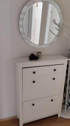 a white dresser with a mirror on top of it at More in Vodice