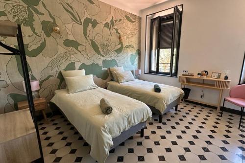 - une chambre avec 2 lits et une fresque murale florale dans l'établissement Chambre Pivoine au Domaine de l'Aven, à Villeneuve-Minervois