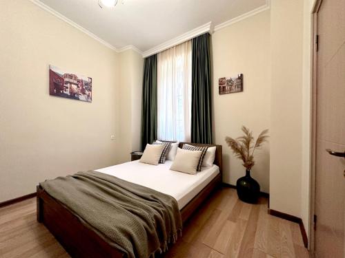a bedroom with a large bed with a window at Betlemi Old Town Hotel in Tbilisi City