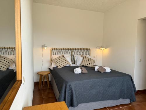 a bedroom with a bed with a blue blanket and pillows at Sea View Villa - Close from Beach - Rovinia in Liapades