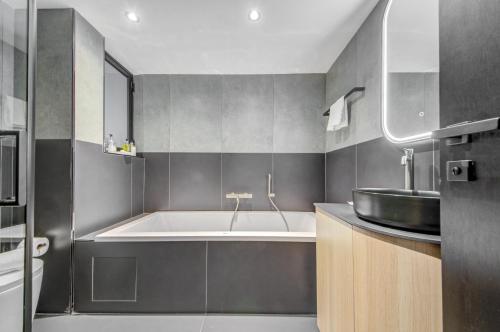 a bathroom with a tub and a sink at Noru Hotel Malta - Adults Only Hotel in St Julian's