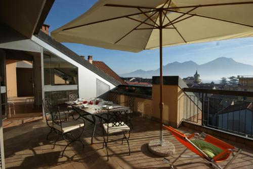 a patio with a table and an umbrella on a balcony at Sinfonia Martini in Verbania