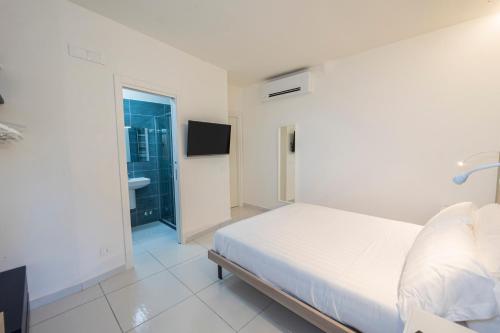 a white bedroom with a bed and a bathroom at Aquamaris Design Suite & Spa in Paestum