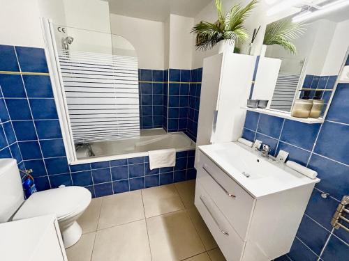La salle de bains est pourvue de carrelage bleu, de toilettes et d'un lavabo. dans l'établissement ApartHotel Riviera - Villa Massena - Grimaldi Promenade des Anglais, à Nice