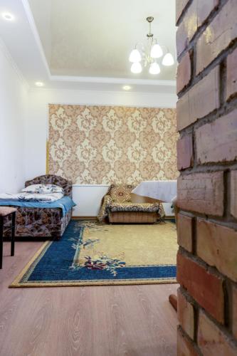 a room with two beds and a brick wall at Guest house and yurt camp Svetlana in Bokonbayevo