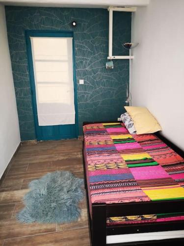 une chambre avec un lit avec un tapis sur le sol dans l'établissement Studio avec kitchenette salle de bain et wc partagé, à Toulon