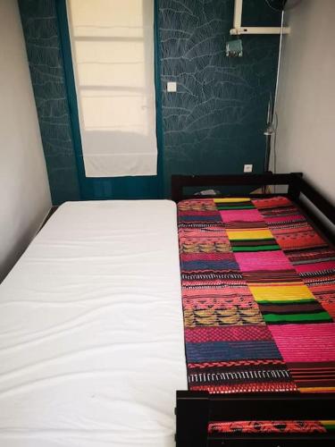 - une chambre avec un lit doté d'un tapis coloré dans l'établissement Studio avec kitchenette salle de bain et wc partagé, à Toulon