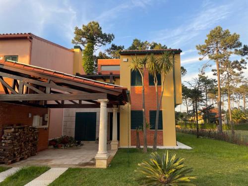 a house with a porch and a roof at À Beira Lago - Casa de férias in Mira