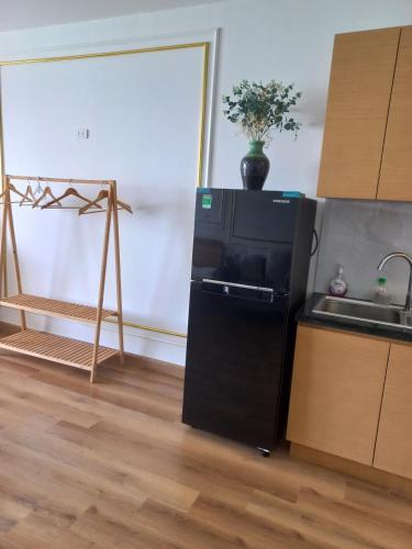 a kitchen with a black refrigerator and a sink at Căn hộ TMS Quy Nhơn KIM NGÂN in Quy Nhon