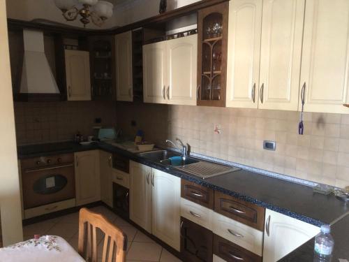 a kitchen with white cabinets and a sink at Lucas apartaments in Vlorë