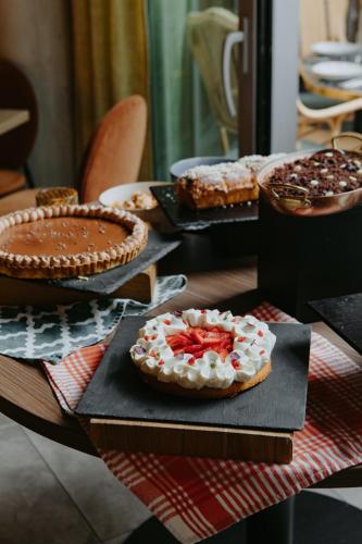 a table topped with cakes and pies on plates at Drawing House in Paris
