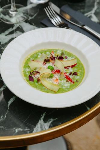 a white plate with a bowl of soup on a table at Drawing House in Paris