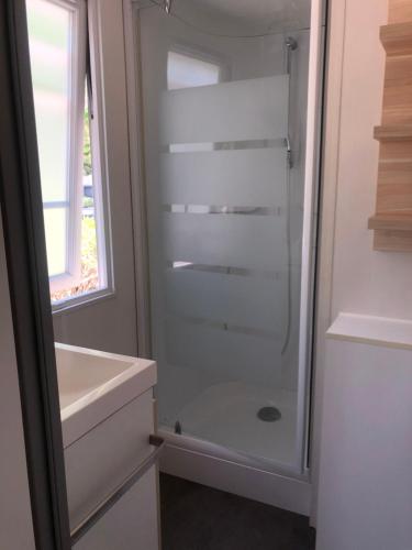une salle de bain avec une douche en verre avec un lavabo dans l'établissement Camping Sainte Victoire, à Beaurecueil