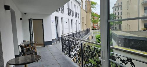 a balcony with a table and chairs and a window at Hotel Villa Sophia in Cologne