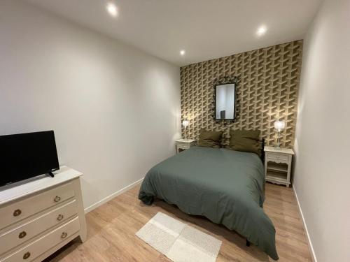 une chambre avec un lit et une télévision à écran plat dans l'établissement gite du petit bois, à Gémenos