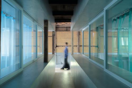 a person walking down a hallway in a building at SEW STAY Soft Seam KYOTO MAIZURU in Maizuru