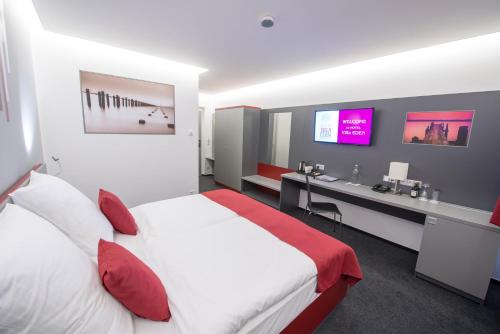 een hotelkamer met een groot bed en een bureau bij Hotel Villa Eden in Jihlava