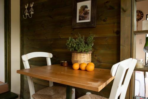 a table with a potted plant and oranges on it at Orgon Farm Traditional Houses in Apóstoloi