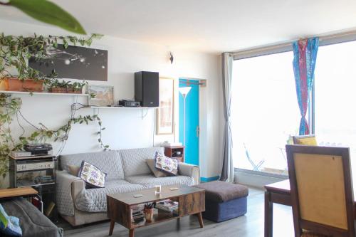 un salon avec un canapé et une table dans l'établissement Lovely T2 with breathtaking views of Paris, à Paris