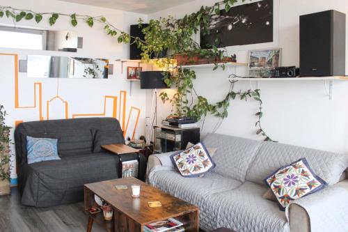 un salon avec un canapé et une chaise dans l'établissement Lovely T2 with breathtaking views of Paris, à Paris