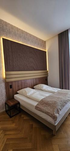 a bedroom with a large bed with a wooden headboard at Hotel Villa Sophia in Cologne