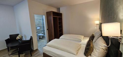a small room with a bed and a desk and a window at Hotel Villa Sophia in Cologne