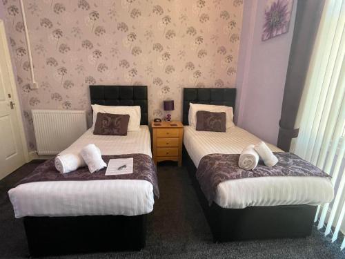 two twin beds in a room with at Milverton House in Llandudno