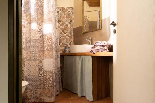 a bathroom with a sink and a shower curtain at Orgon Farm Traditional Houses in Apóstoloi