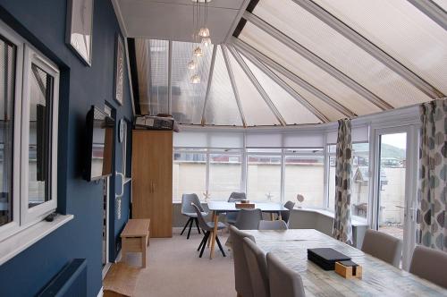 a dining room with a table and some chairs at Sound of the Sea, beach front Bungalow with hot tub, in Tywyn in Tywyn