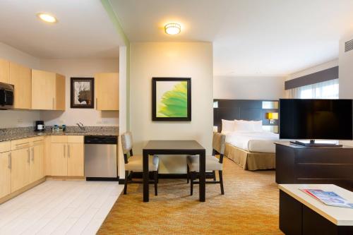 a hotel room with a bed and a table and a kitchen at Residence Inn by Marriott San Jose Escazu in San José