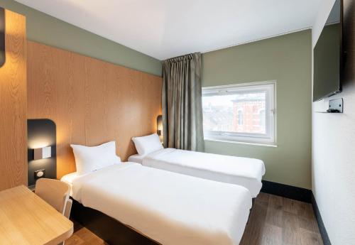 a hotel room with two beds and a window at B&B HOTEL Lille Roubaix Campus Gare in Roubaix