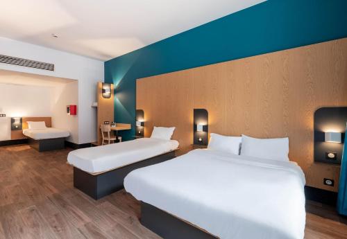a hotel room with two beds and a blue wall at B&B HOTEL Lille Roubaix Campus Gare in Roubaix