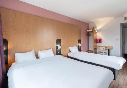 two beds in a hotel room with white sheets at B&B HOTEL Lille Roubaix Campus Gare in Roubaix