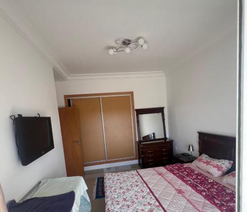 a bedroom with a bed and a flat screen tv at Marina golf asilah in Asilah