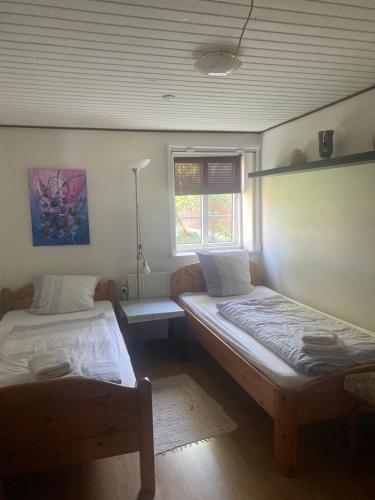 two beds in a room with a window at Ferienzimmervermietung Reitferien in Skærbæk