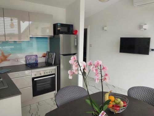 a kitchen with a table with a vase of flowers at Villa Sunce Funtana in Funtana