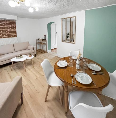 un salon avec une table, des chaises et un canapé dans l'établissement Séjour Élégant à la Porte de Lille, à Seclin