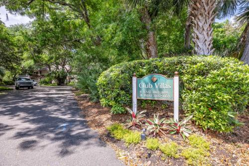Un cartel de un club de villas frente a un arbusto. en 3025 Club Villas, en Fernandina Beach