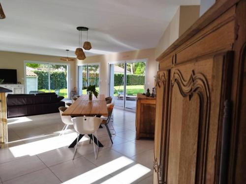 une cuisine et un salon avec une table et des chaises dans l'établissement calme villa spacieuse pensée pour10 proche mer, à Saint-Hilaire-de-Riez