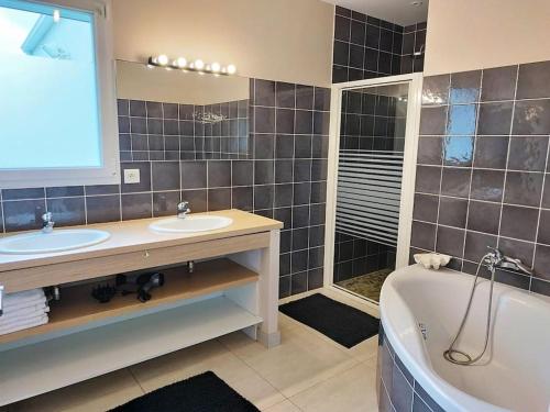 La salle de bains est pourvue d'une baignoire, de 2 lavabos et d'une baignoire. dans l'établissement calme villa spacieuse pensée pour10 proche mer, à Saint-Hilaire-de-Riez