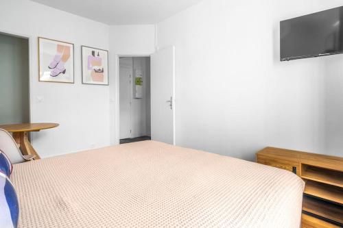 une chambre avec un lit et une télévision à écran plat dans l'établissement Studio paisible en banlieue parisienne - Montreuil, à Montreuil