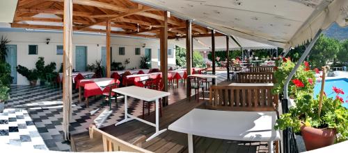 a restaurant with tables and chairs on a deck at Theofilos Classic Hotel in Petra
