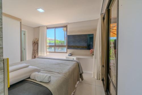 a bedroom with a large bed and a window at Mandara Lanai Apartamento Terreo in Aquiraz