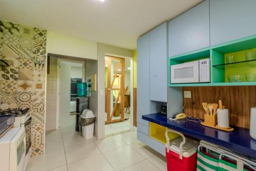 a kitchen with a blue counter and a microwave at Mandara Lanai Apartamento Terreo in Aquiraz