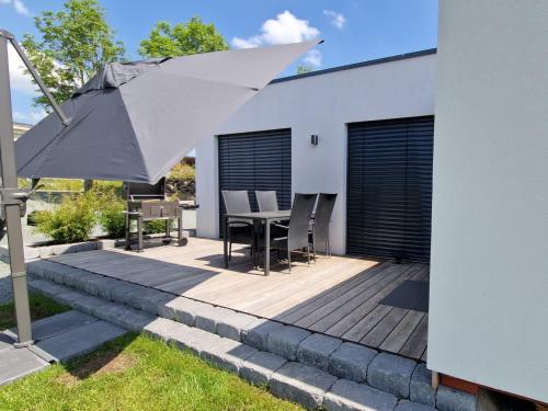 a patio with an umbrella and a table and chairs at Bergkultur Sauerland in Medebach