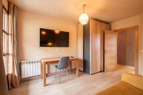 a room with a desk with a chair and a television at Apartamento El Mirador del Puerto in Llanes