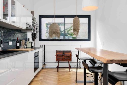 une cuisine avec une table et des chaises et une fenêtre dans l'établissement Loft contemporain - Bordeauxlidays, à Bordeaux