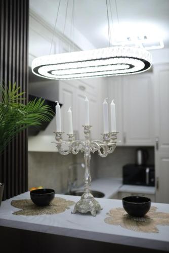 a kitchen with a chandelier and two bowls on a table at Imperial Lux Apartment in Kragujevac